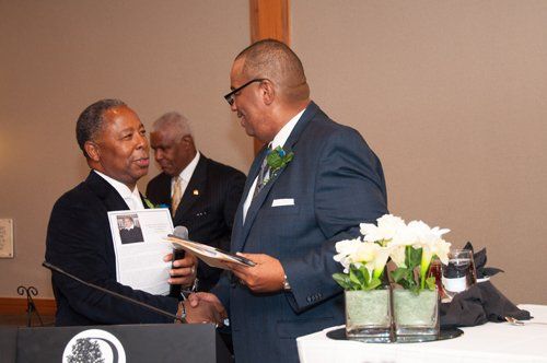 Two men shaking hands at an event.