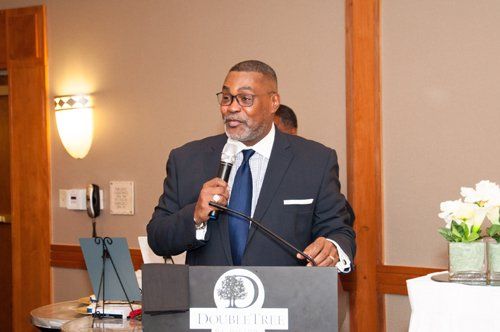 Man in suit speaks at a podium with 