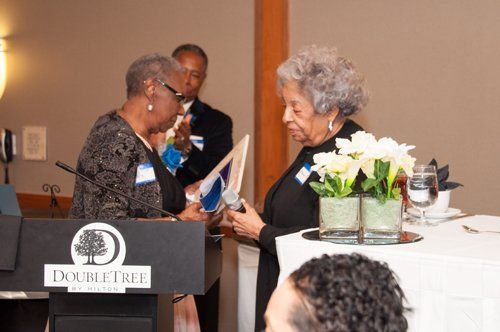 Woman receives an award at the DoubleTree hotel podium.