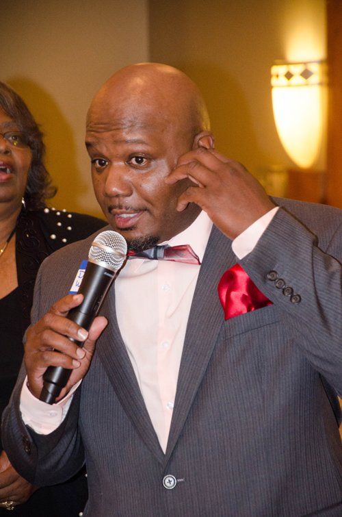 Man in suit holding a microphone, 