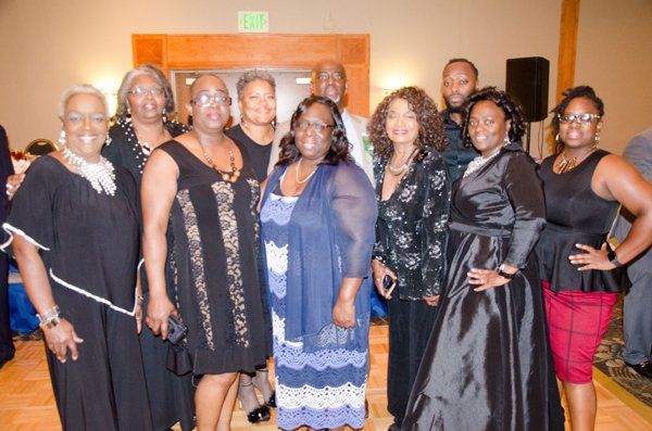 Group of people posing for a photo at an event, wearing formal attire.