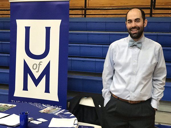 Man wearing a bow tie stands near a 