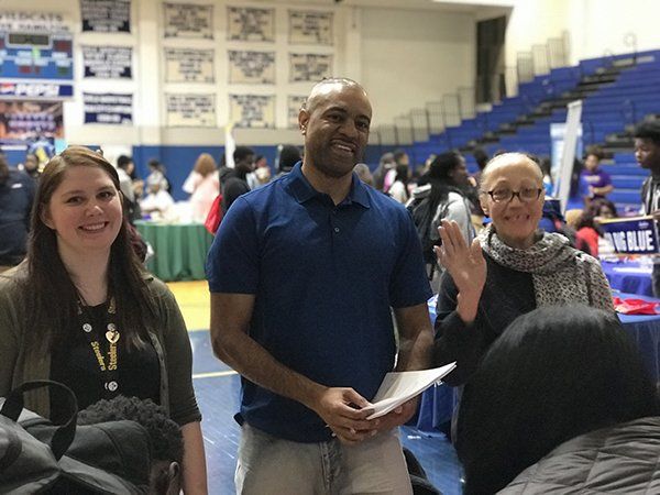 Three people smiling at an event:
