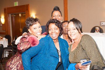 Group of smiling people pose for a photo at an event.