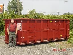 Man Beside Dumpster — Dumpster Rentals in Columbus, OH Man Beside Dumpster — Dumpster Rentals in Columbus, OH