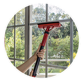a person is cleaning a window with a squeegee .