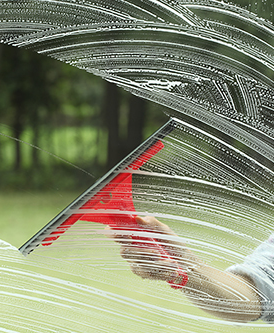 a person is cleaning a window with a squeegee .
