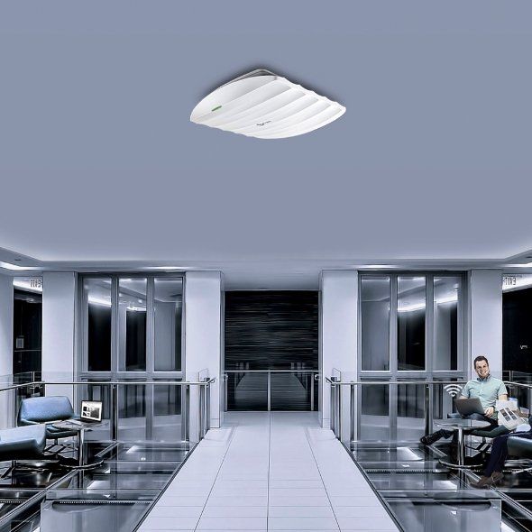 Modern office lobby with glass walls, central walkway, and people seated at desks on both sides