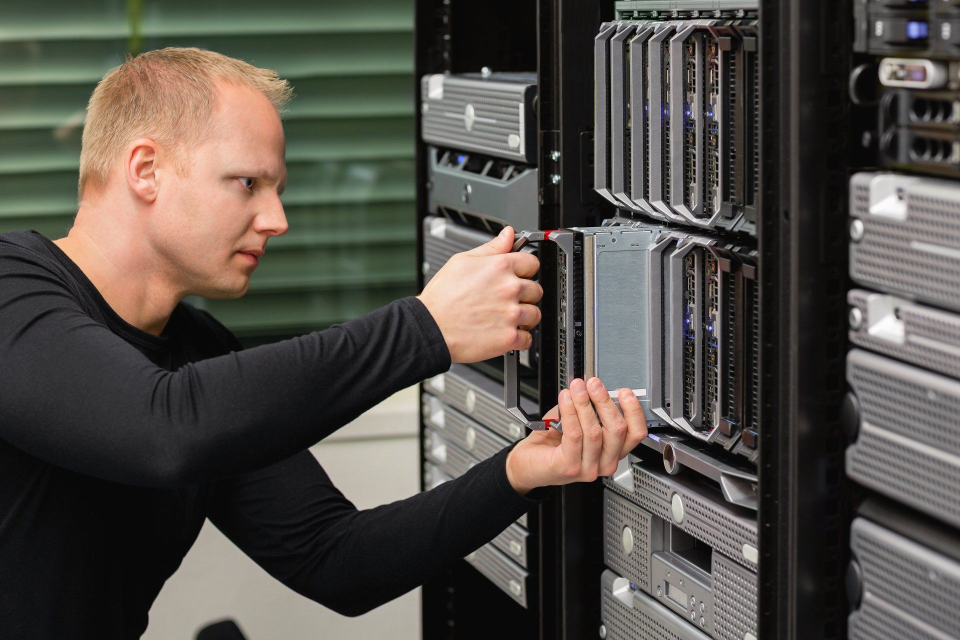 Technician adjusting a server rack in a data center