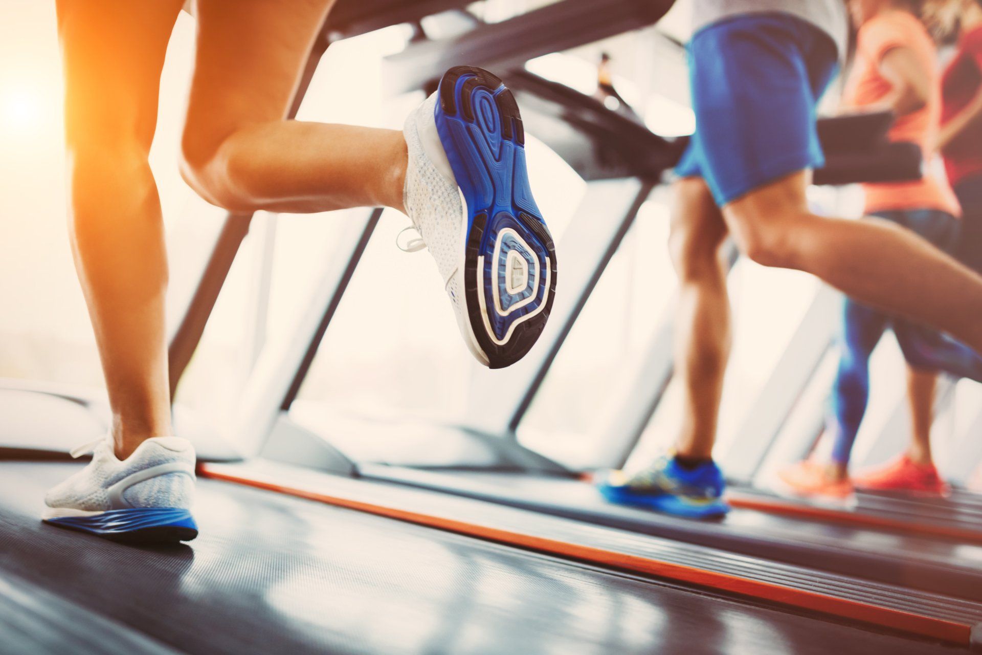 A group of people are running on treadmills in a gym.