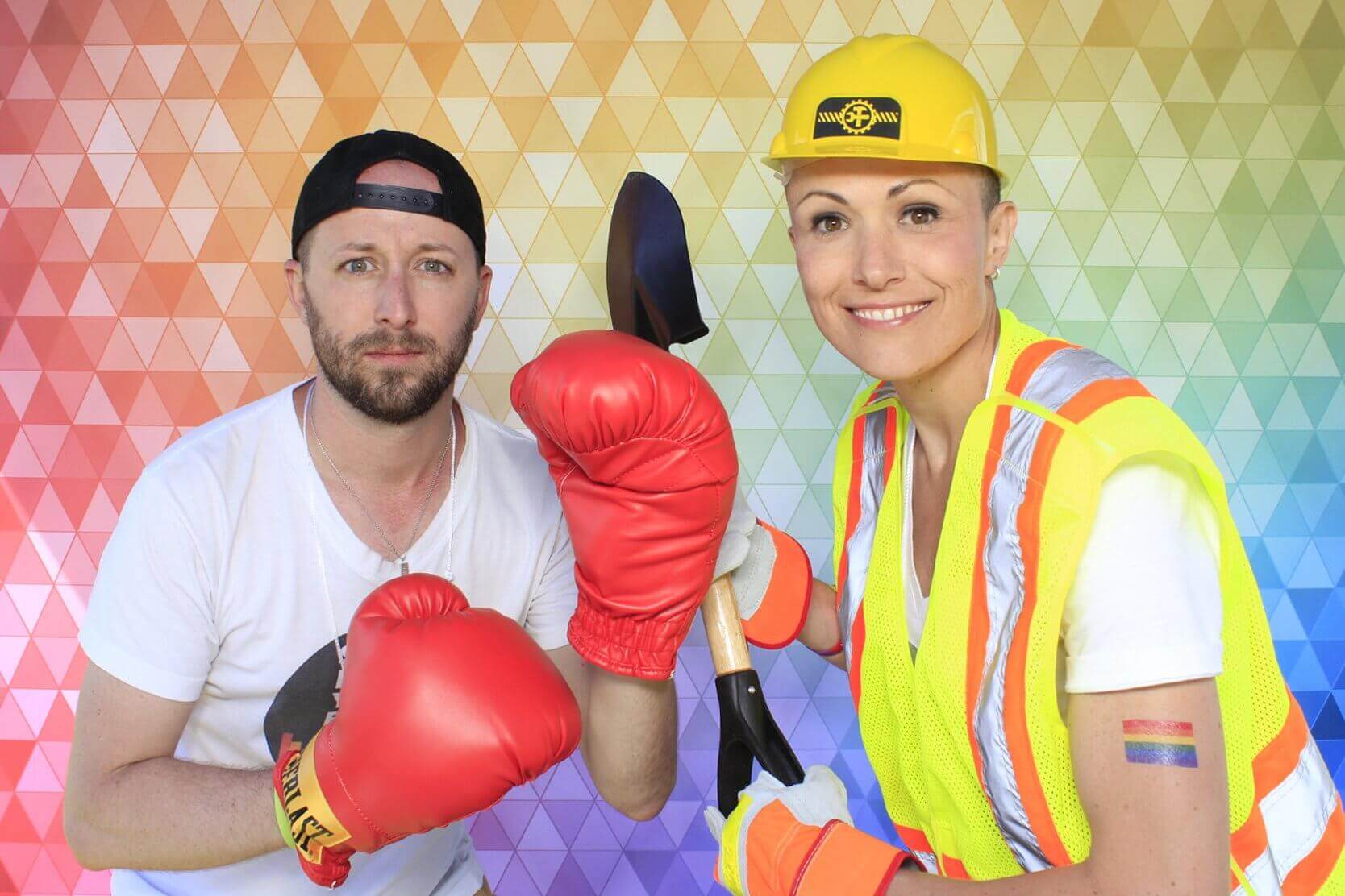 Man in white shirt and boxing gloves, woman in construction gear holding shovel, against rainbow background.