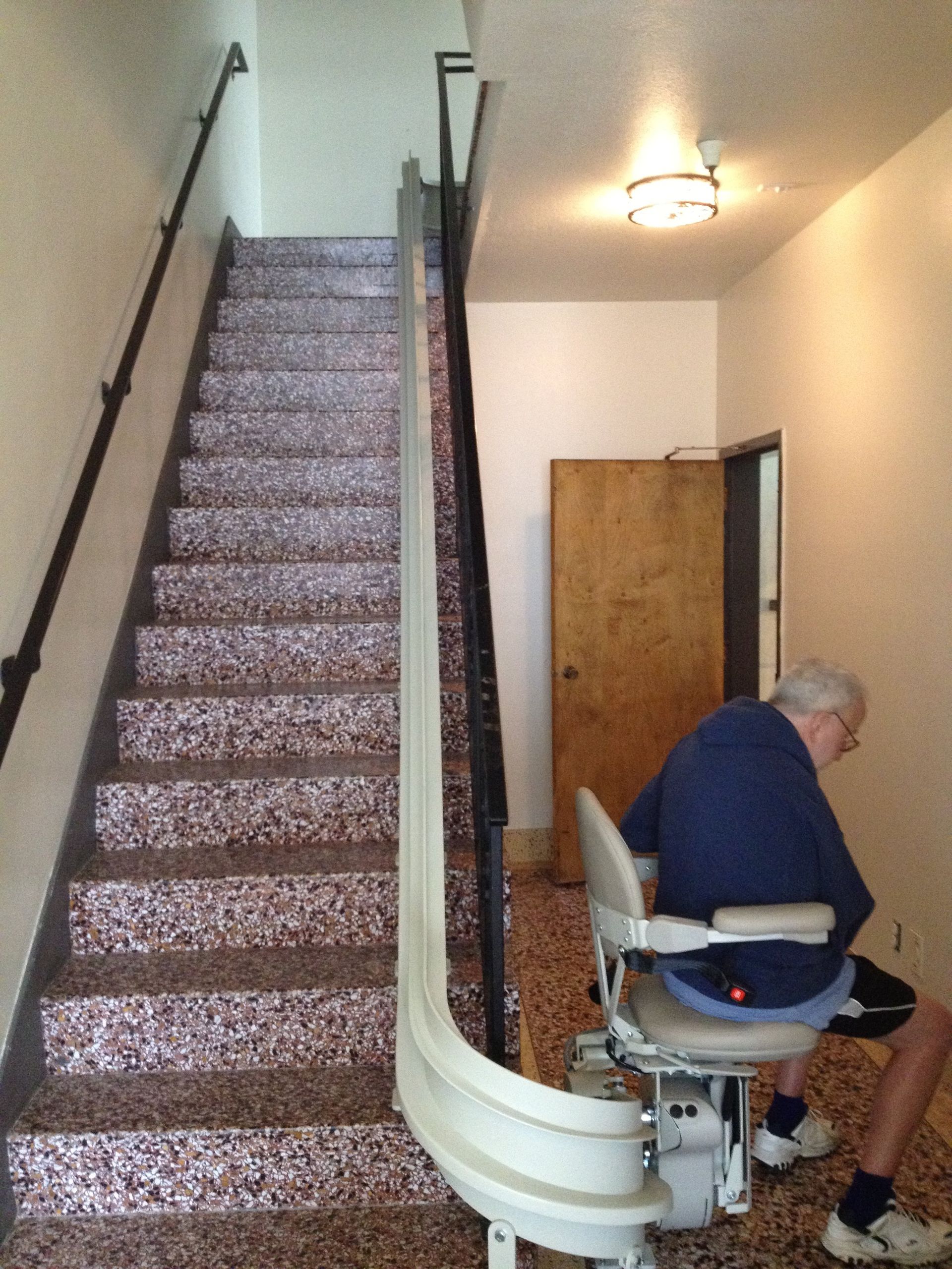 Man Sitting in Chair Lift on Ground Floor