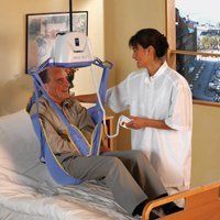 Woman lifting patient with hoyer 