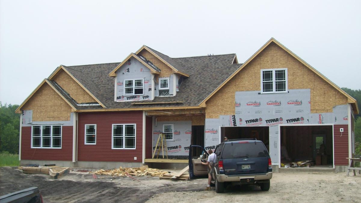 Insulation contractor getting out of vehicle to look at home in Windham, ME