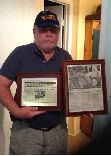Owner Holding News Paper On A Frame — Charleston, SC — Captain Mikes Clock Shop Owner Holding News Paper On A Frame — Charleston, SC — Captain Mikes Clock Shop