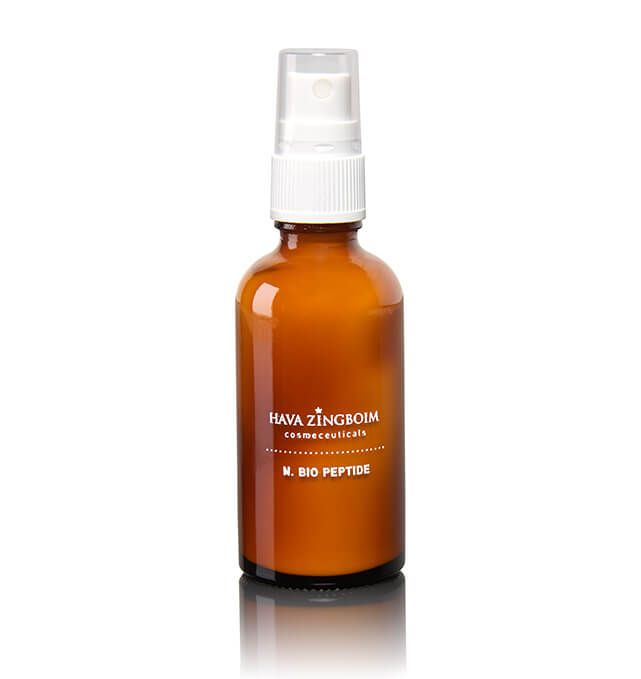 A brown spray bottle with a white cap is sitting on a white surface.