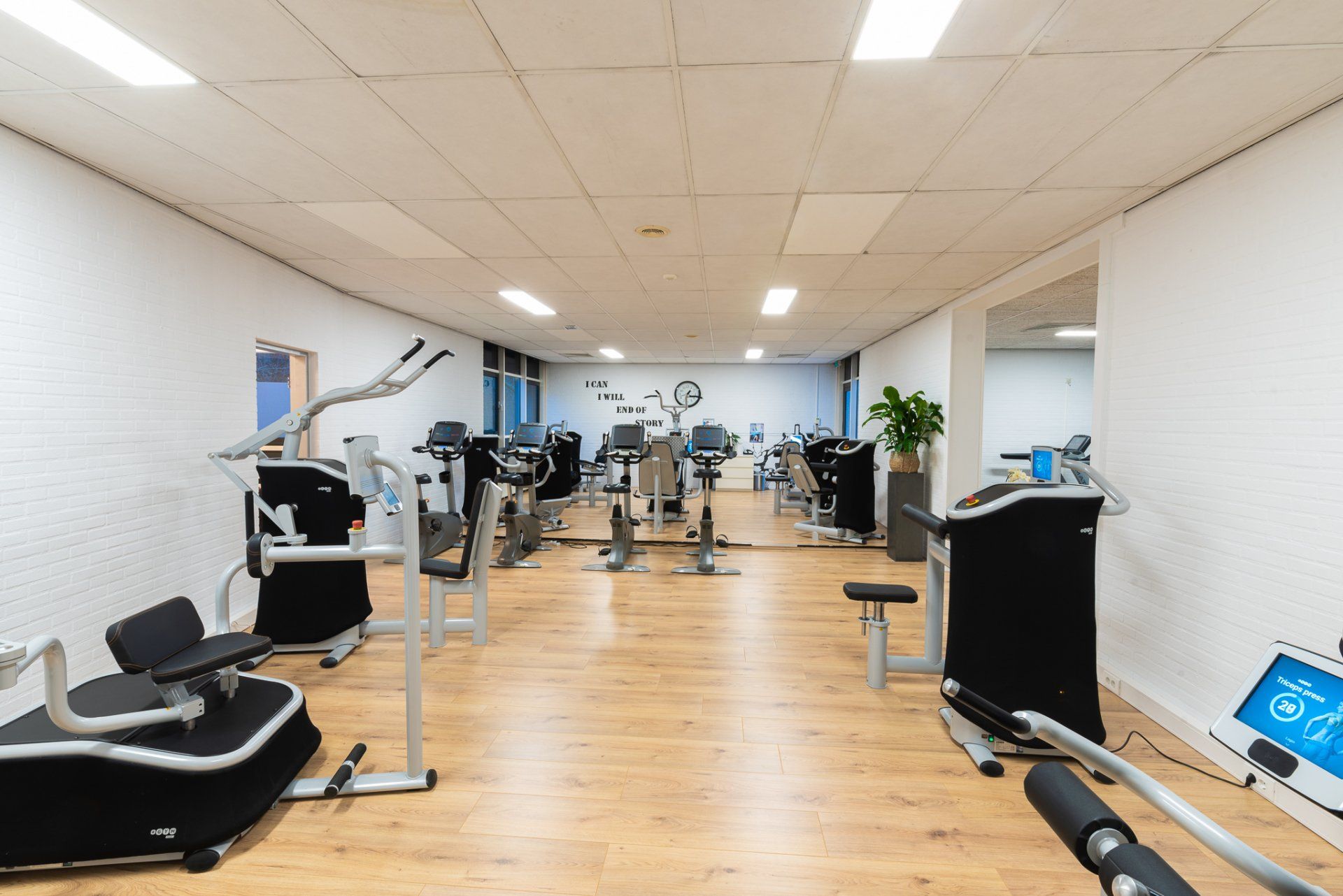 Een grote fitnessruimte vol met veel fitnessapparatuur.