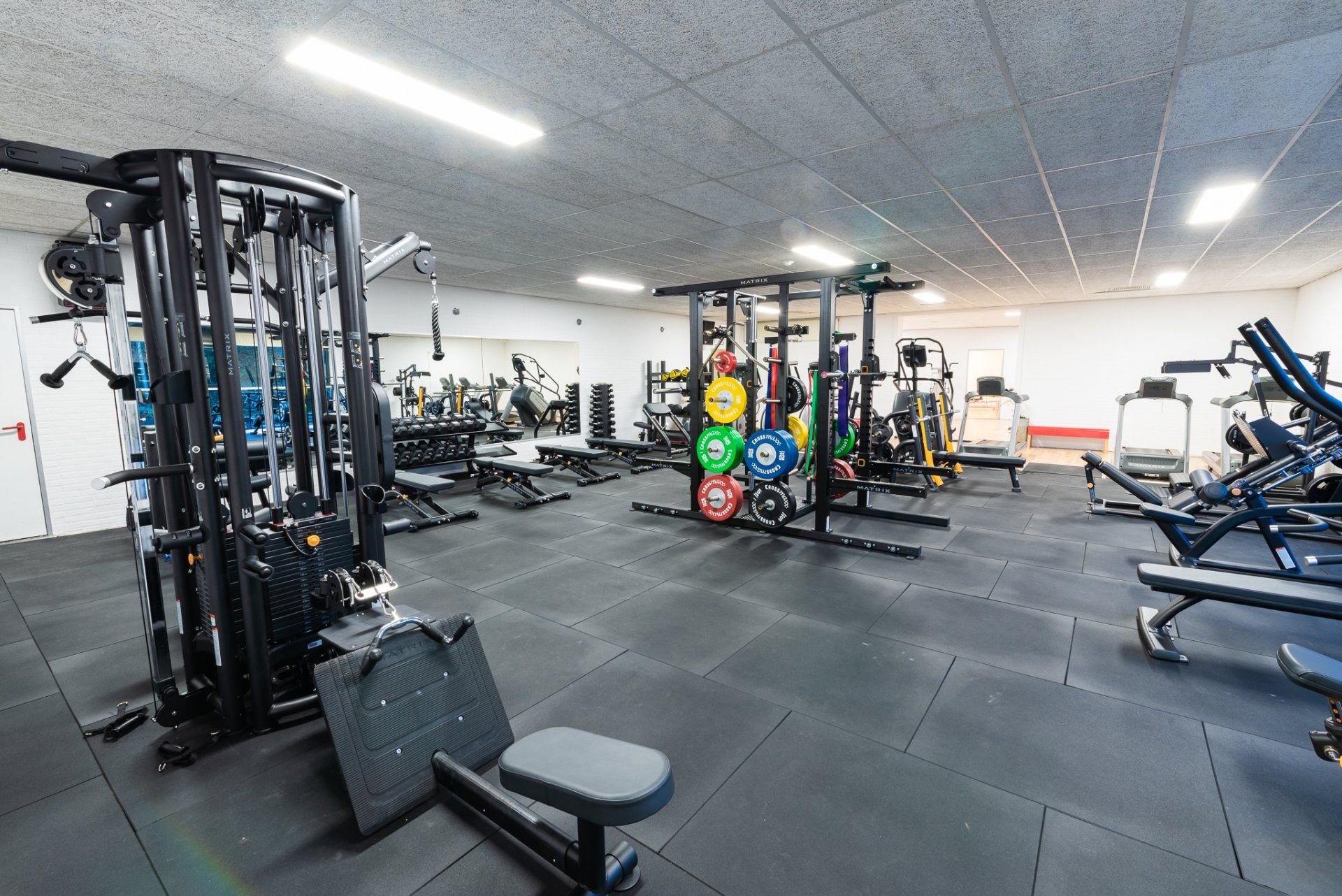 Een grote fitnessruimte vol met veel fitnessapparatuur.