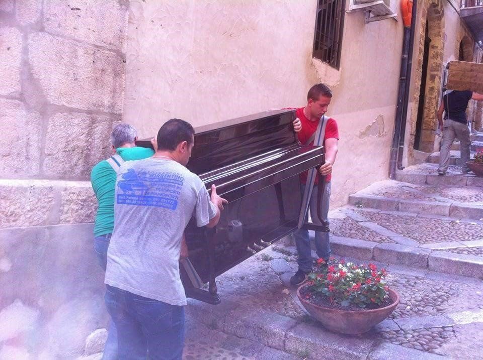 Operazioni di trasloco a braccia di un pianoforte