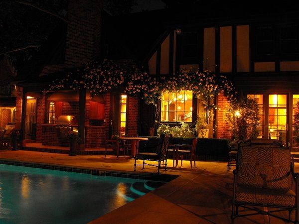 A house with a swimming pool is lit up at night