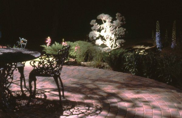 A table and chairs are sitting on a patio at night.