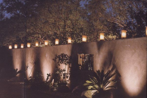 A row of lanterns are lit up on the side of a wall