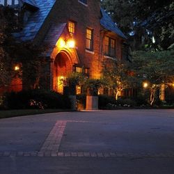 A large brick house is lit up at night