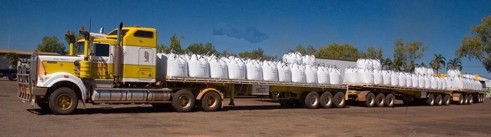 A yellow and white semi truck with a trailer full of bags- Slingshot Haulage in Katherine, NT