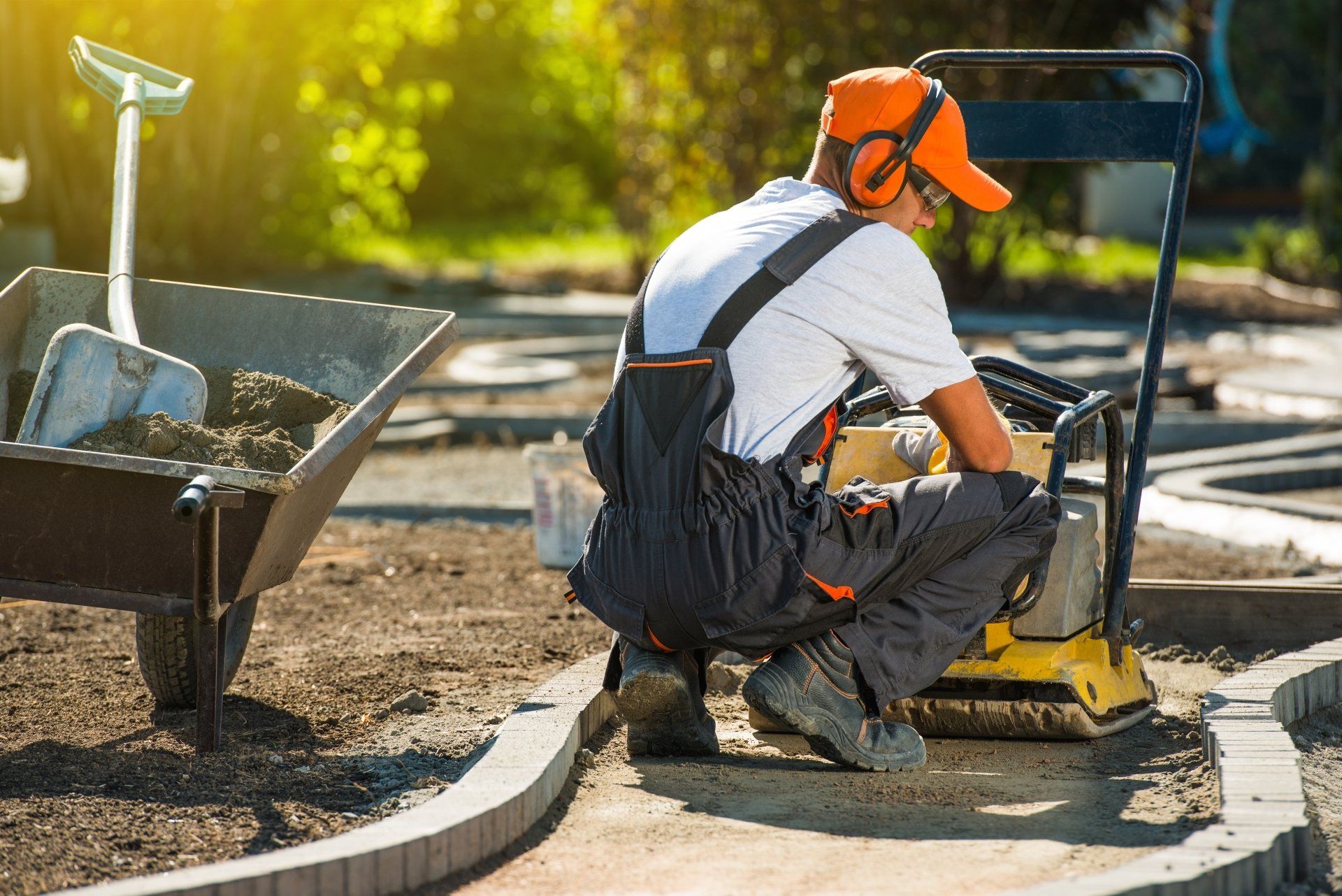 A man is sitting on the ground using a machine.