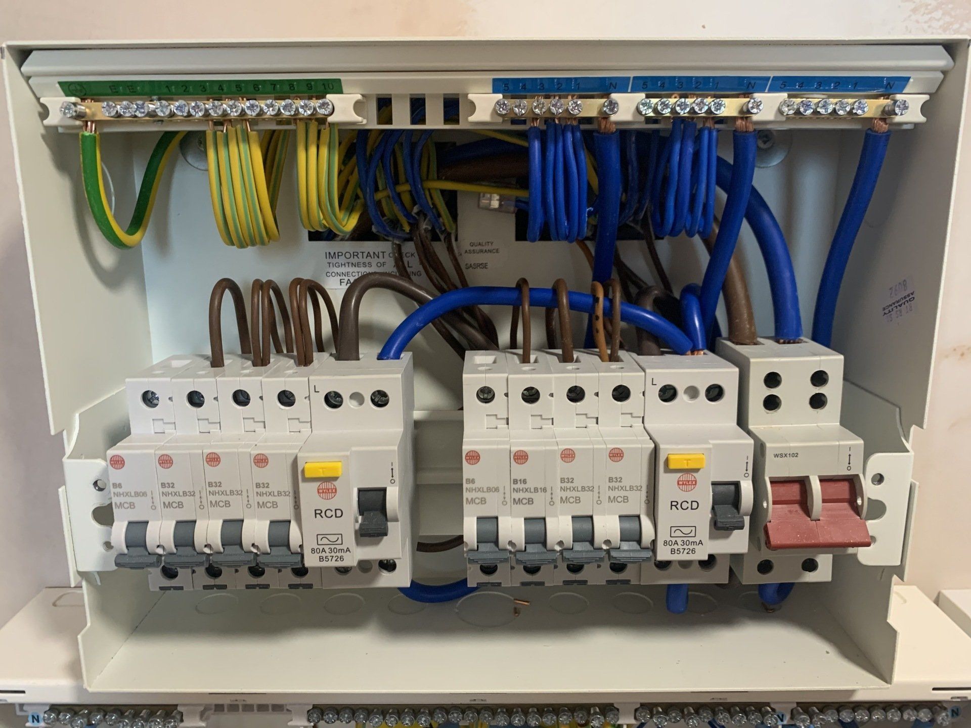 The inside of a electrical box with a bunch of wires coming out of it.