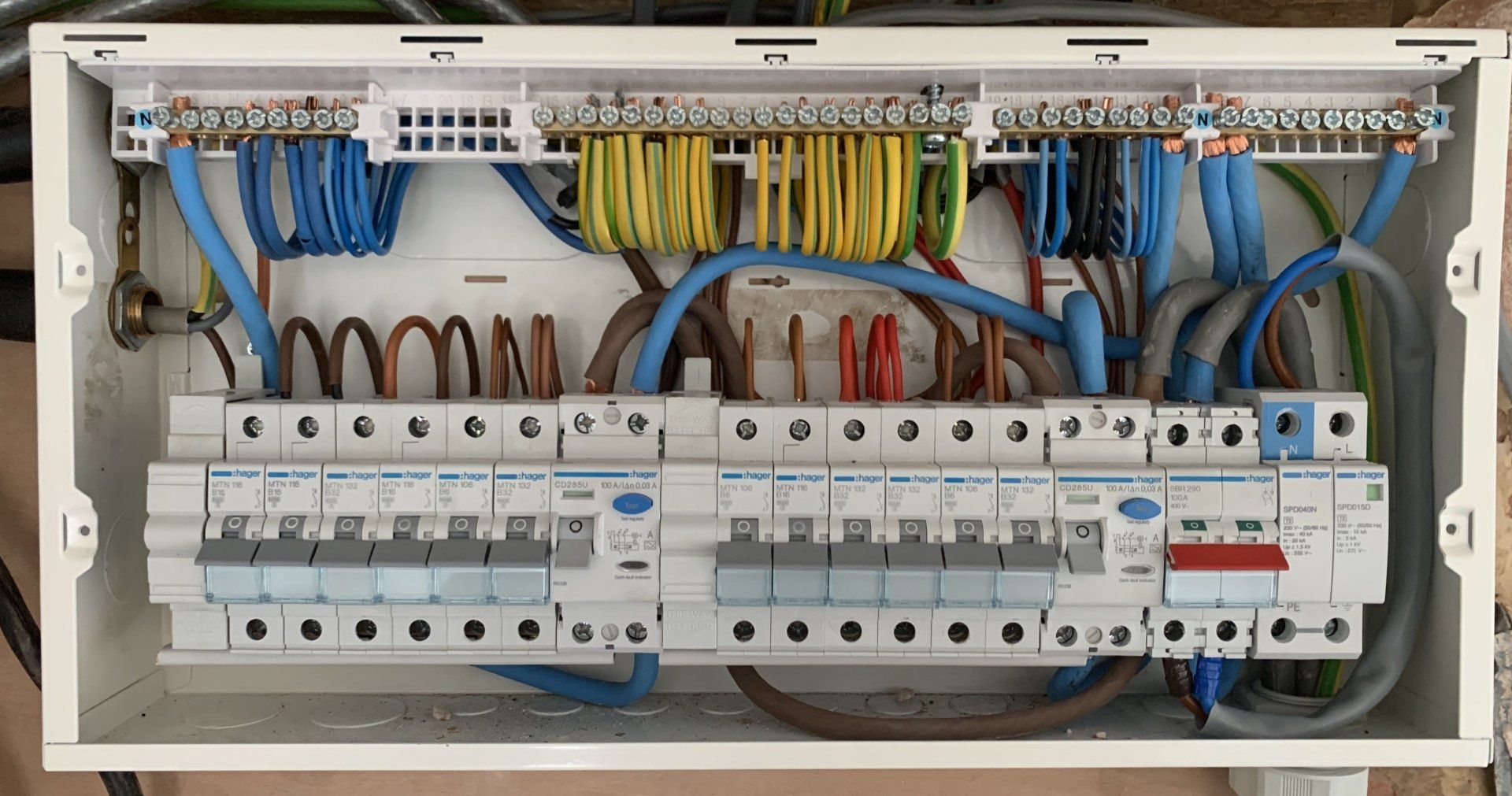 A close up of a electrical box with a lot of wires coming out of it.