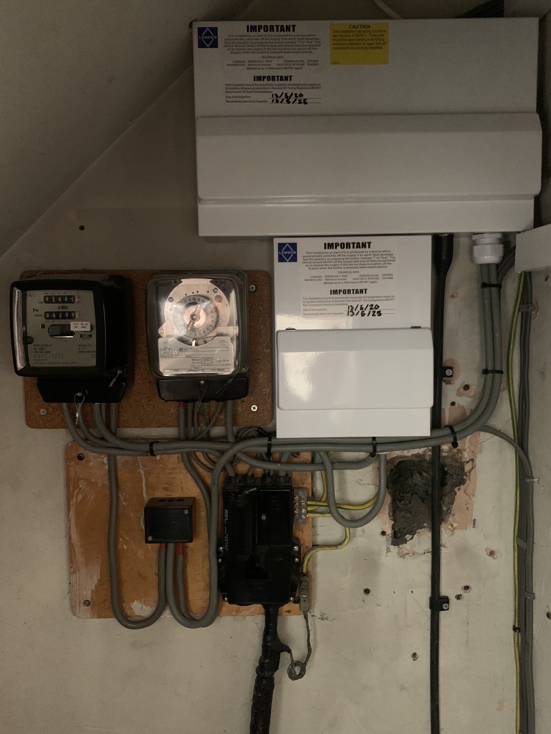 A wall with a bunch of wires and electrical boxes on it