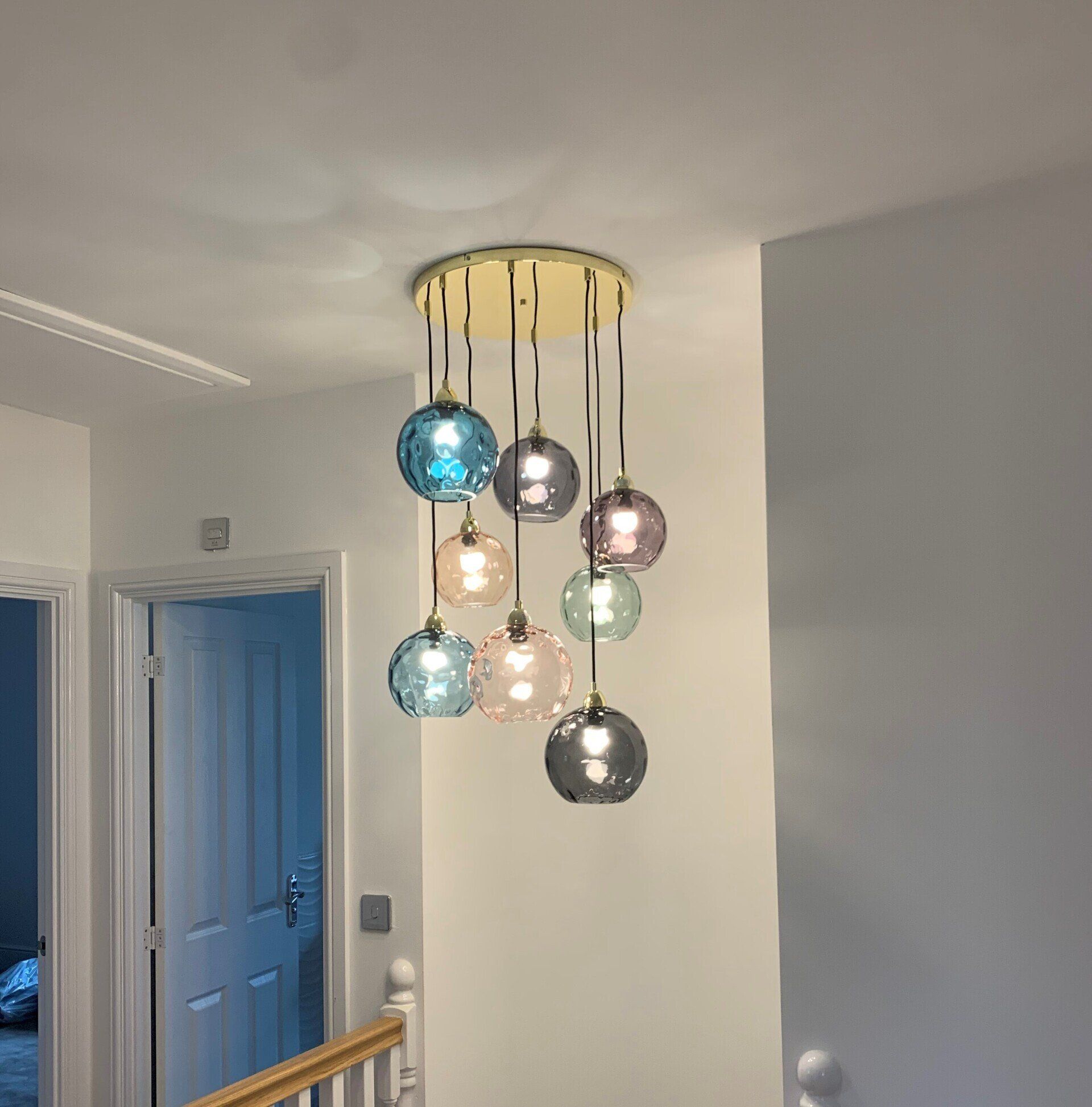 A chandelier is hanging from the ceiling in a hallway.