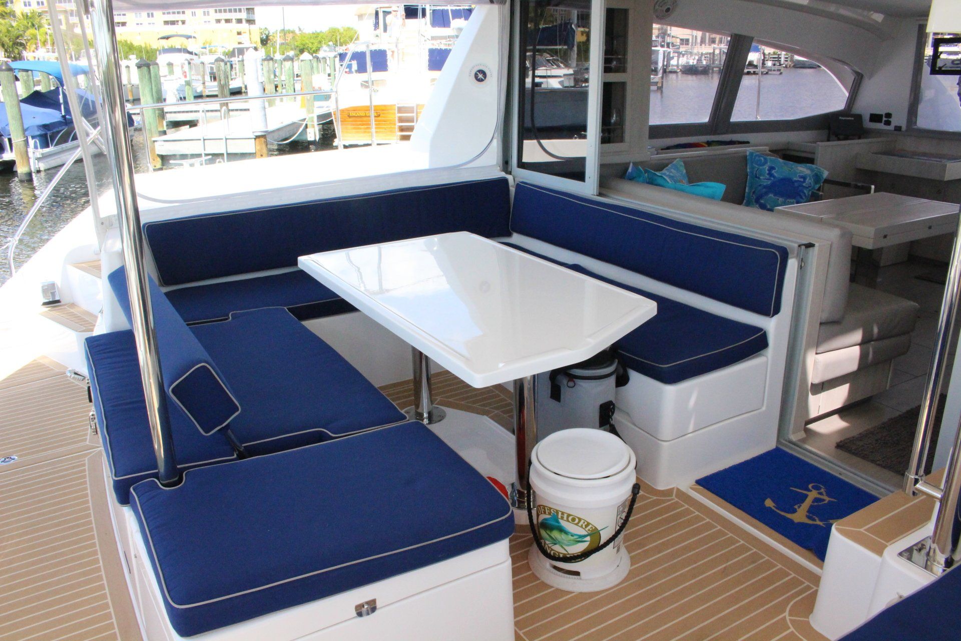 The inside of a boat with a table and a bucket on the floor.
