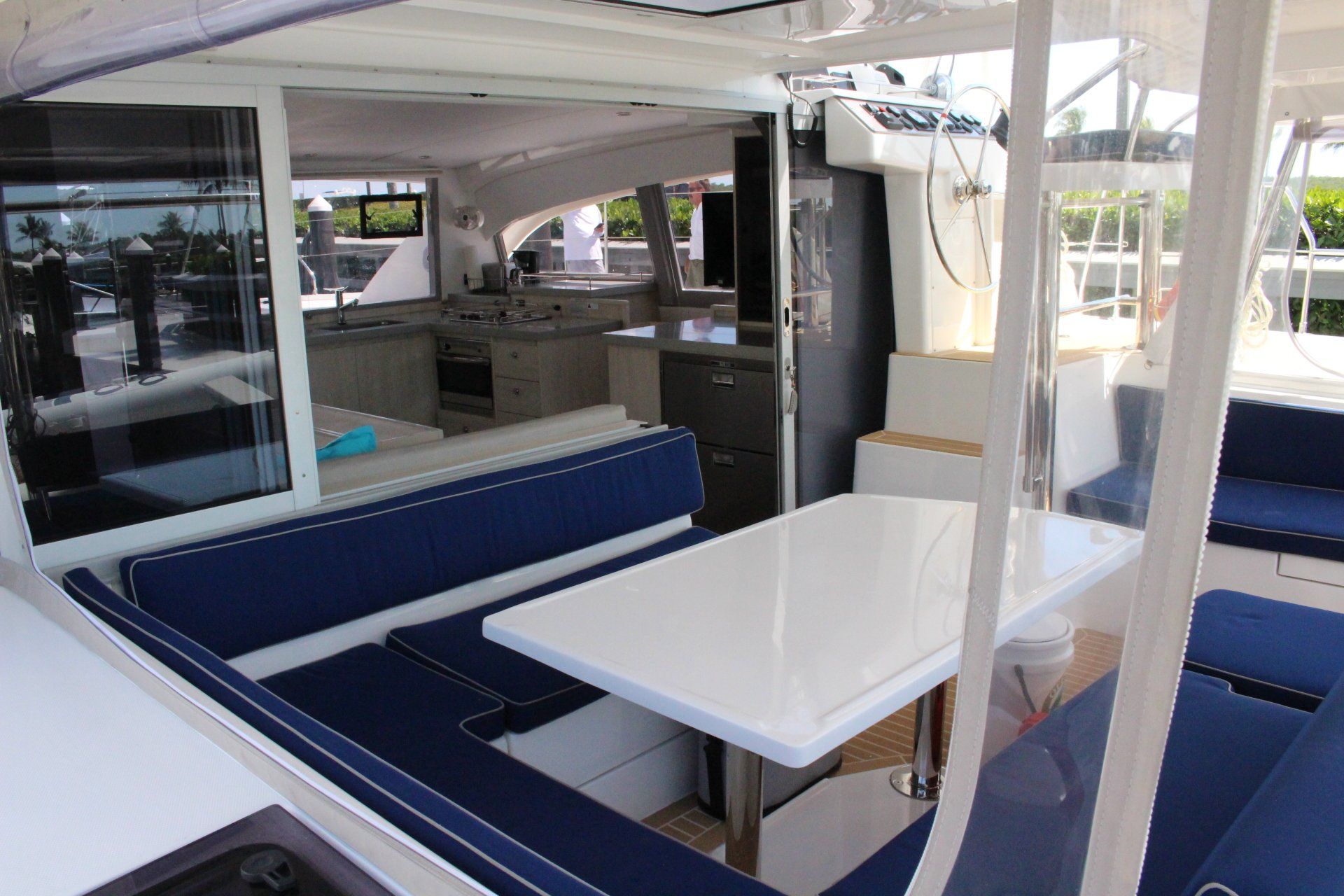The inside of a boat with a table and blue cushions
