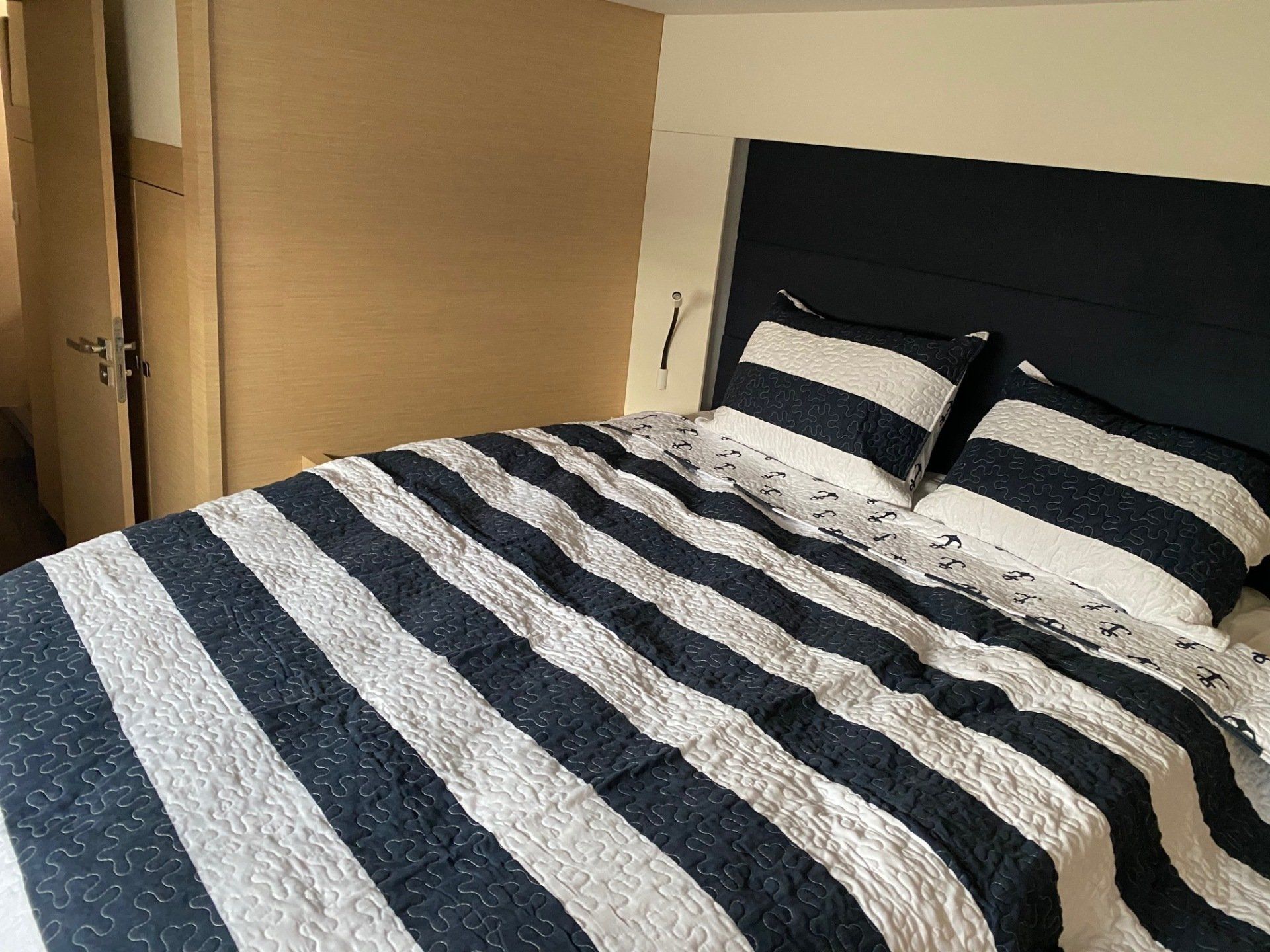 A bed with a black and white striped comforter and pillows