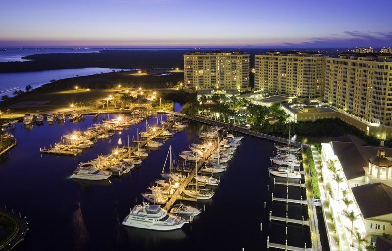 An aerial view of a marina at night with many boats docked
