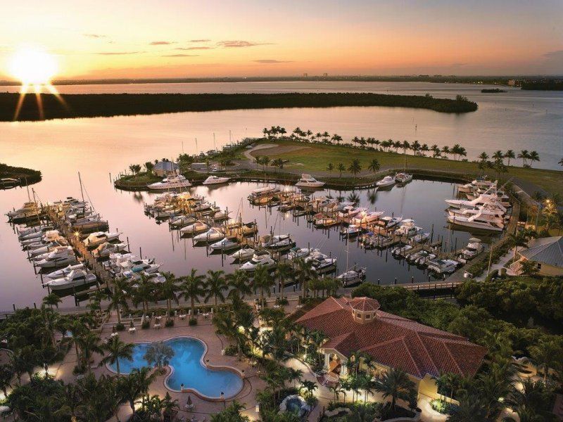 An aerial view of a marina with boats and a pool at sunset