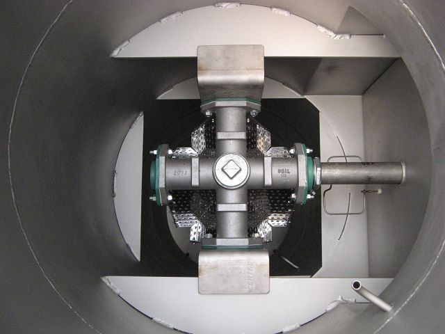 Inside a metal tank, a cross-shaped mixing apparatus with blades.
