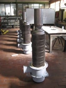 Eine Reihe von Metallrohren liegt in einem Raum neben einem Tisch.