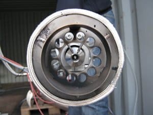 Eine Person hält einen Metallgegenstand mit Löchern darin.