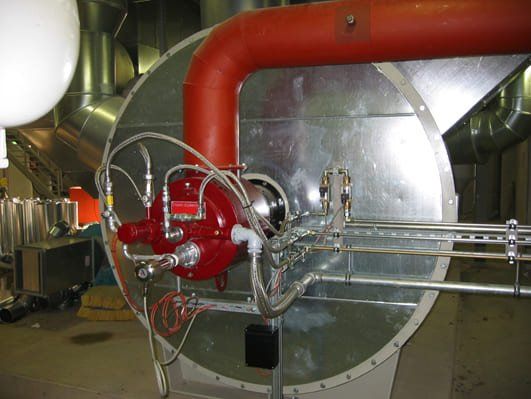 Ein großes Metallrohr mit einem daran befestigten roten Schlauch
