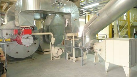 Eine Fabrik mit vielen Rohren und Maschinen darin.