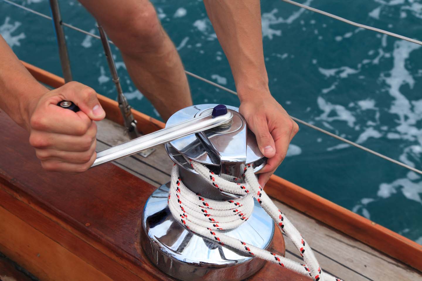 Skipper di un'imbarcazione slega la corda dalla galloccia