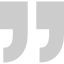 A pair of gray quotation marks on a white background.