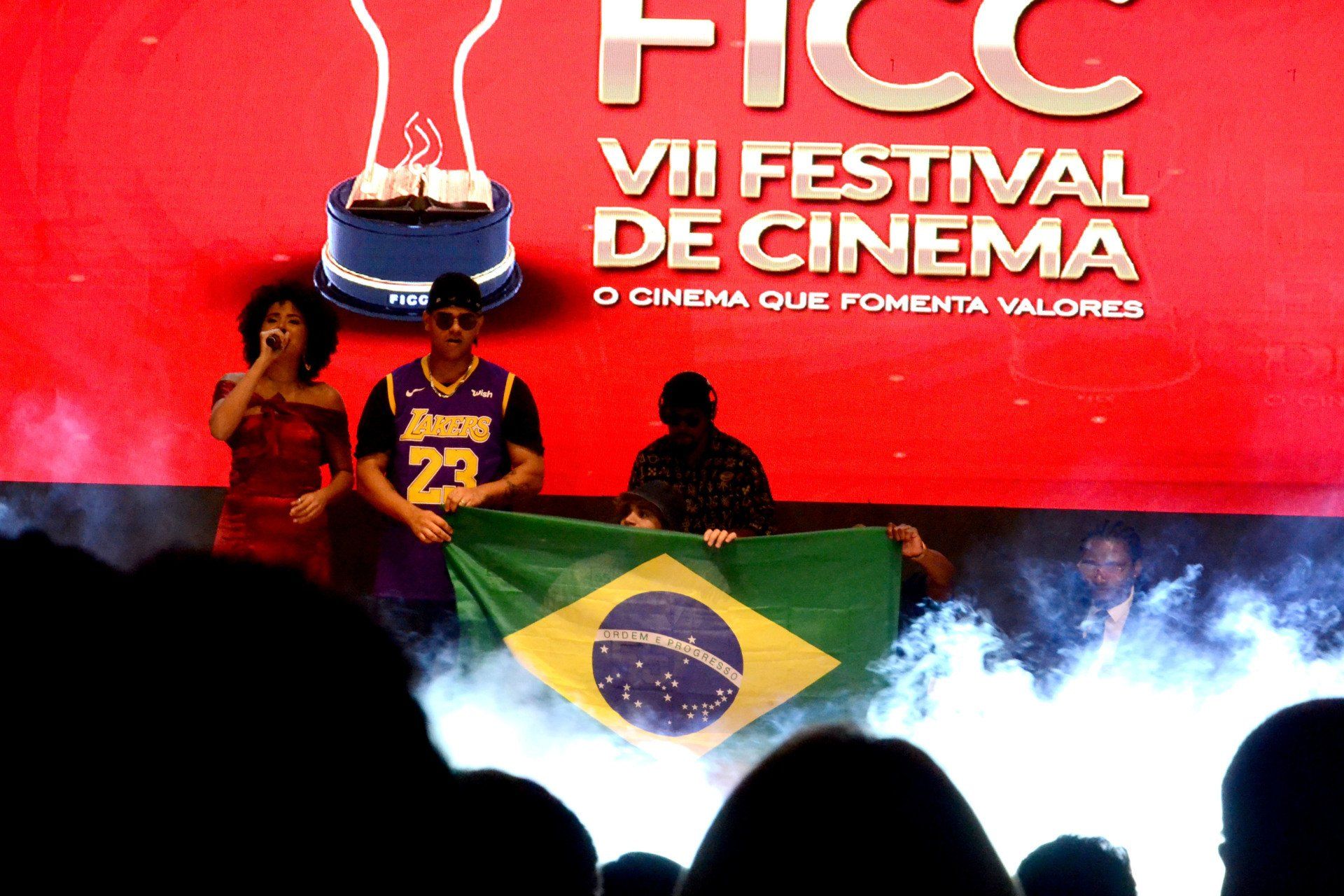Um homem com uma camisa do lakers segura uma bandeira brasileira