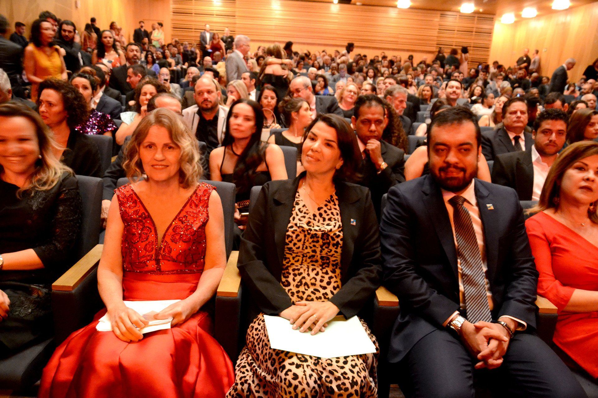 Um grupo de pessoas está sentado em um grande auditório.
