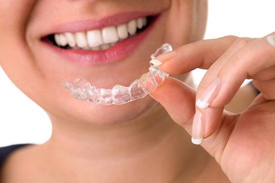 Woman holding Invisalign, Dentist in Cicero, IL
