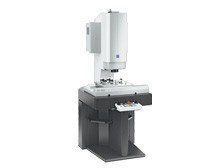 A microscope is sitting on top of a table on a white background.