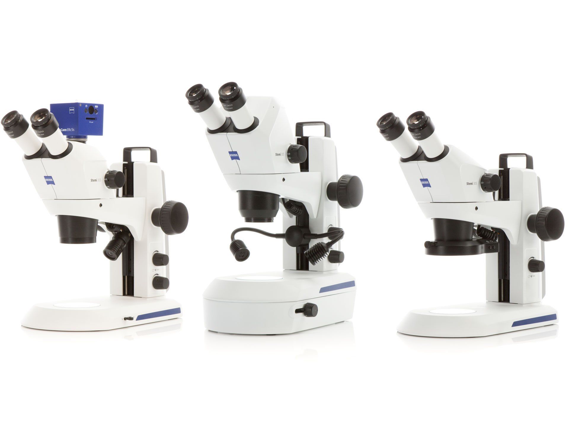 Three microscopes are sitting next to each other on a white surface.